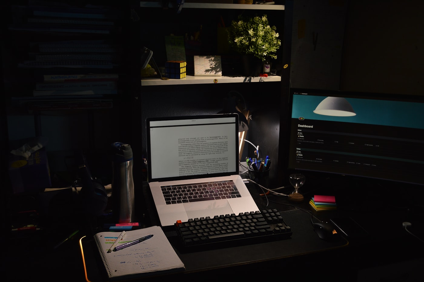 A student working at a laptop in a dark room